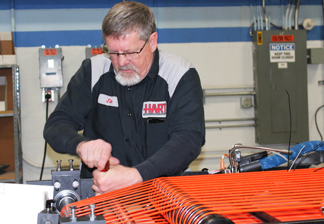 HART Design & Manufacturing shop employee fixing a machine