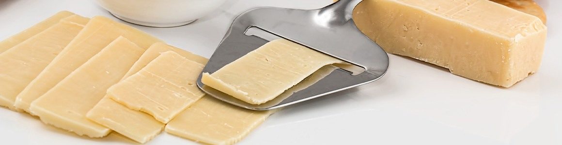 Slices of cheese with a tool to slice.