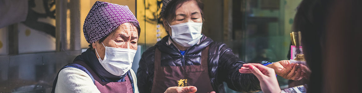 Korean women wearing masks exchanging money.