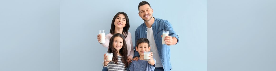 Family holding glasses of milk with milk moustaches.