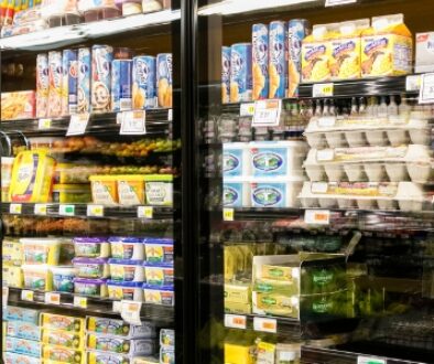 Deli meats, butter, eggs, and breakfast items in the refrigerator secton of a grocery store.