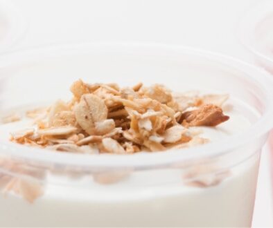 Yogurt in cups with various flavors including blueberries, strawberries, and granola.