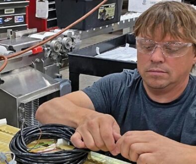 HART Design & Manufacturing works with wiring on industrial machinery.