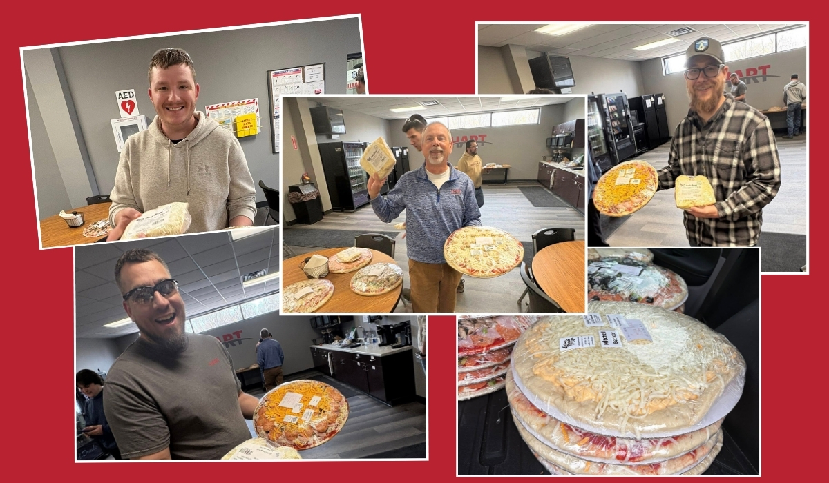 HART Design & Manufacturing employees hold large pizzas from Eaton’s Fresh Pizza in Sheboygan during a team pizza treat at the office.