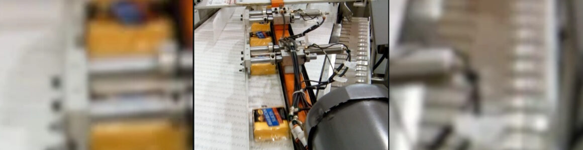 HART Design & Manufacturing automated conveyor system transporting packaged cheese products through food processing equipment.