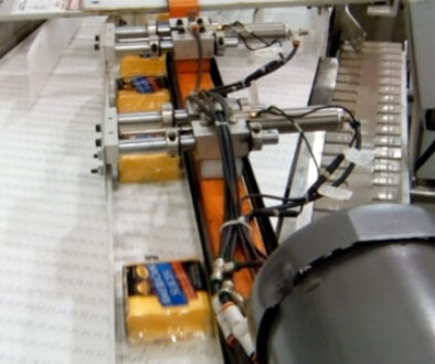 HART Design & Manufacturing automated conveyor system transporting packaged cheese products through food processing equipment.