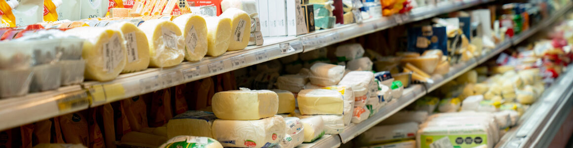 Variety of packaged cheese products displayed on grocery store shelves, highlighting different dairy packaging formats.