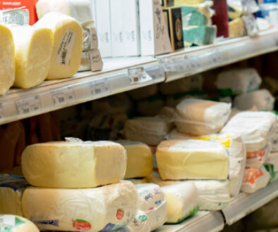Variety of packaged cheese products displayed on grocery store shelves, highlighting different dairy packaging formats.